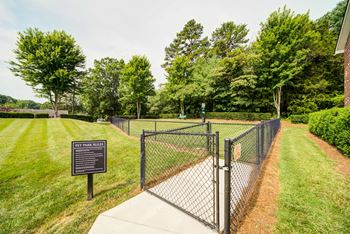 Double Gated Dog Park with grass and trees around.